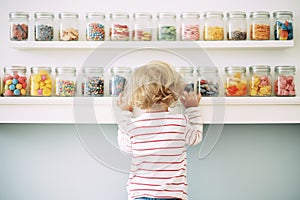 a child choosing from a variety of candy jars
