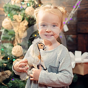 Child with a Christmas present on wooden background. Happy children. New year kids. kiddy. Portrait of happy child