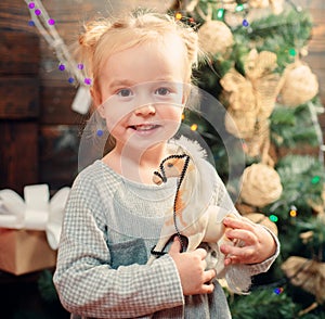 Child with a Christmas present on wooden background. Happy children. New year kids. kiddy. Portrait of happy child