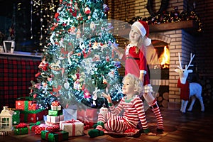 Child at Christmas tree. Kids at fireplace on Xmas