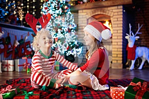 Child at Christmas tree. Kids at fireplace on Xmas