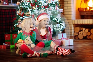 Child at Christmas tree. Kids at fireplace on Xmas