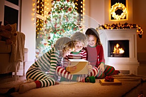 Child at Christmas tree. Kids at fireplace on Xmas