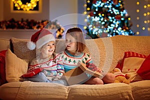 Child at Christmas tree. Kids at fireplace on Xmas