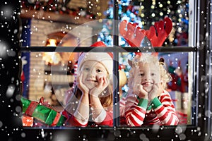 Child at Christmas tree. Kids at fireplace on Xmas