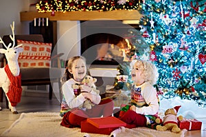 Child at Christmas tree. Kids at fireplace on Xmas