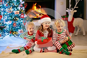 Child at Christmas tree. Kids at fireplace on Xmas