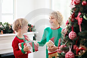 Child at Christmas tree. Kids at fireplace on Xmas