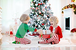 Child at Christmas tree. Kids at fireplace on Xmas