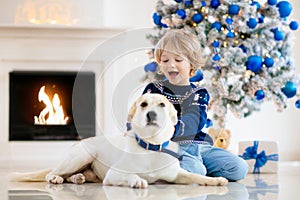 Child at Christmas tree. Kids at fireplace on Xmas