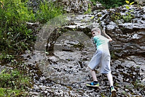 Child climbing rock in Khadzhokh gorge in summer