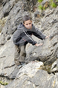 Child climbing rock in nature