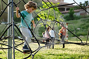 Child climbing on a Rope-ladder web in a playground