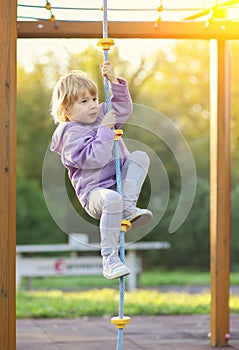 Child climbing rope on playground