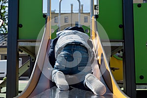 Child climbing a slide in a children`s playground