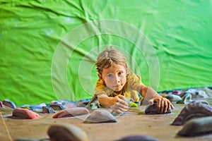 Child climbing on a wall in an outdoor climbing center