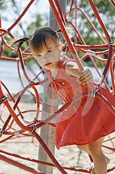 A child climbs on a rope web in the playground