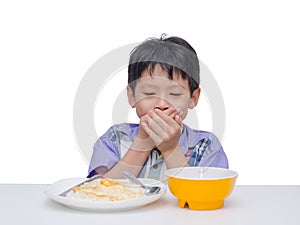 Child close his mouth by hand between having lunch