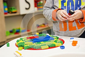 The child collects the Designer. Kids activity in kindergarten or at home. Child plays with a children`s designer