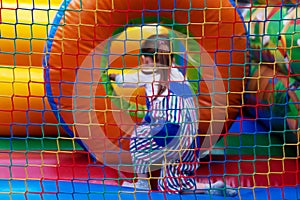 A child on a colorful trampoline. A happy little girl is having fun on an inflatable playground. The baby is playing in an inflata