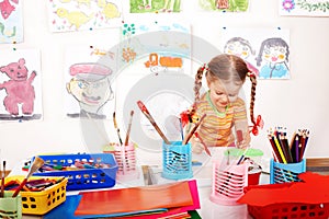 Child with colour pencil in play room.