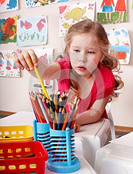 Child with colour pencil in preschool.