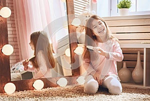 Child is combing near mirror