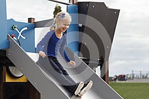 Child Coming down Playground Slide. Happy Children Playing on Playground