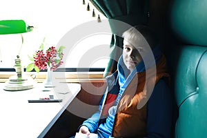 Child in compartment of retro train carriage