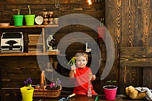 Child concept. Little child with gardening tools. Cute child in garden shed. Happy child gardener