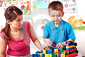 Child with construction set in play room.