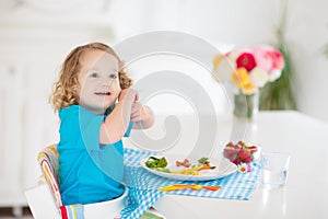 Child cooking, eating. Kids cook in kitchen