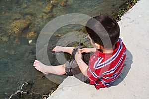 Child cooling feet in water