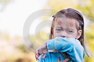 Child coughing or sneezing into arm