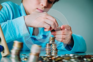 Child counting money, boy collectiong coins, saving concept