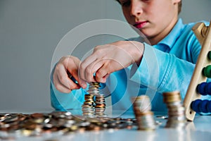 Child counting money, boy collectiong coins, saving concept