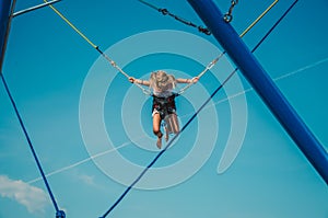 Child with courage jumping high up to the skies