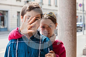 Child covers face of her brother, portrait