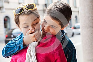 Child covers mouth of his sister, portrait