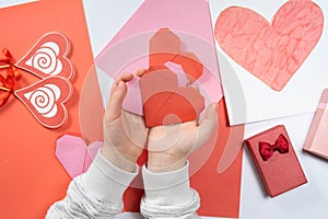 The child creates a hearts out of paper, hands close-up. Origami for Valentine& x27;s Day.