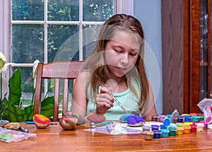 Child creating colorful art on rocks