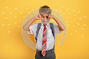 Child cries because does not want to go to school. Yellow background