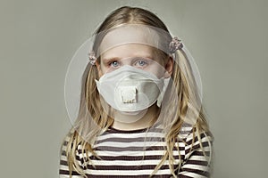 Child crying with tears wearing medical mask on gray background
