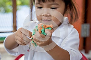 Child cute little girl playing with clay