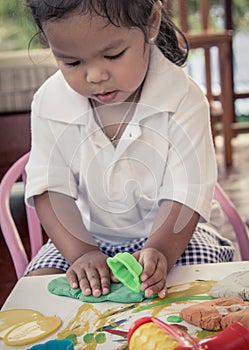 Child cute little girl playing with clay, play doh