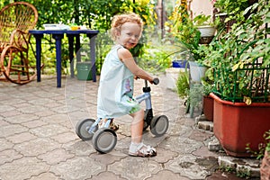 Child cute little girl riding bike outdoors