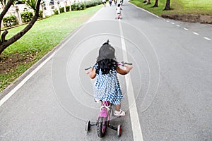 Child cute little girl riding bike