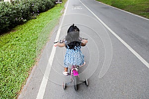 Child cute little girl riding bike