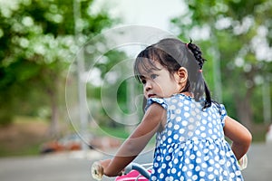 Child cute little girl riding bike