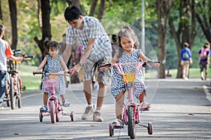 Child cute little girl riding bike in park